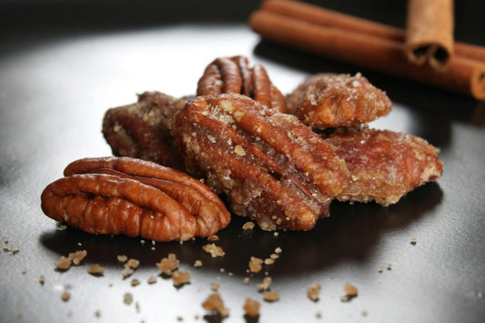 Roasted pecans and a wooden spoon on a table